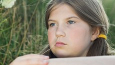 Puberty in adopted children can be especially difficult, as demonstrated by this melancholy girl in a field