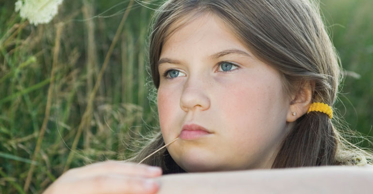 Puberty in adopted children can be especially difficult, as demonstrated by this melancholy girl in a field