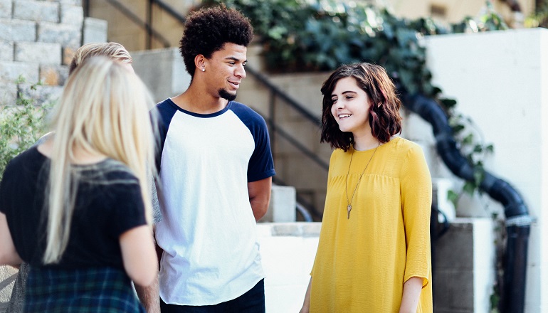 Several teens of different racial heritages talk.