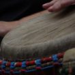 People playing the djembe drum