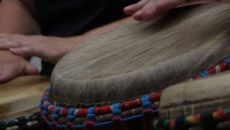 People playing the djembe drum