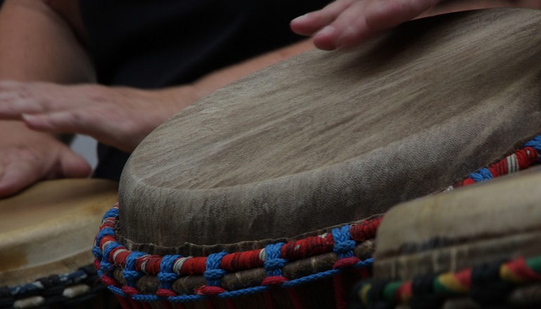 People playing the djembe drum