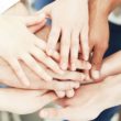 A group of adults put their hands in a circle after starting an adoptive parents support group