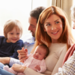 new mother talking to her father about open adoption as the new grandparents admire newborn baby