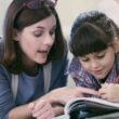 Mother assisting daughter with homeschooling work