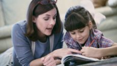 Mother assisting daughter with homeschooling work