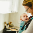 Adoptive mother wears newly adopted baby in baby carrier to help with bonding and adjustment