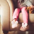 A child sits on the couch and wants privacy, a natural phase of the stages of childhood