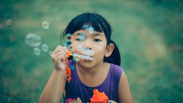 A girl blows bubbles and thinks about transracial families.