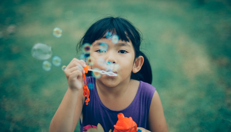 A girl blows bubbles and thinks about transracial families.
