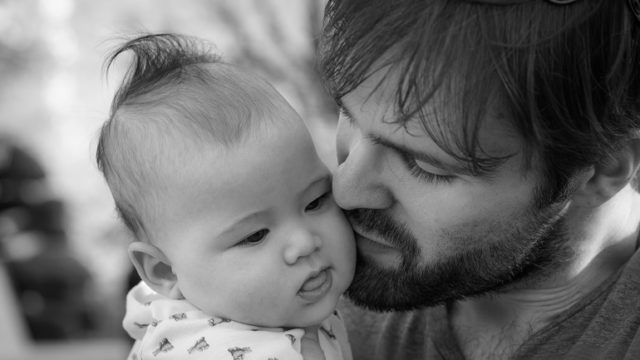 A father holds his infant son and lets go of parental expectations