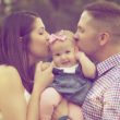 Two parents kiss their infant on the cheeks after preparing for a baby to adopt for so long.