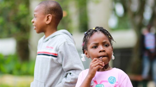 Two siblings in foster care stand outside together