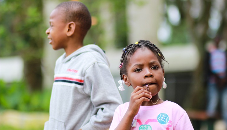 Two siblings in foster care stand outside together