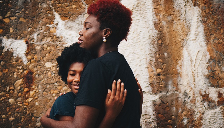 A girl embraces her birth mother after finding birth parents.