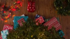 An adoptive mom stands in front of a pile of Christmas gifts