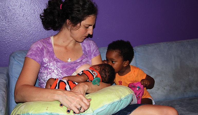 A woman with her children after adoptive breastfeeding.