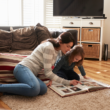 A mother and daughter look at the girl's lifebook, containing photos and words telling her foster adoption story