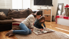 A mother and daughter look at the girl's lifebook, containing photos and words telling her foster adoption story