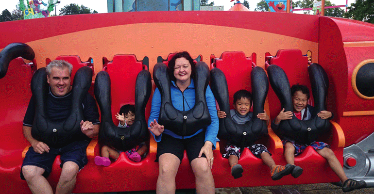 A family at a theme park for their summer adoption plans