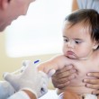 A baby getting a shot, adopting a healthy child