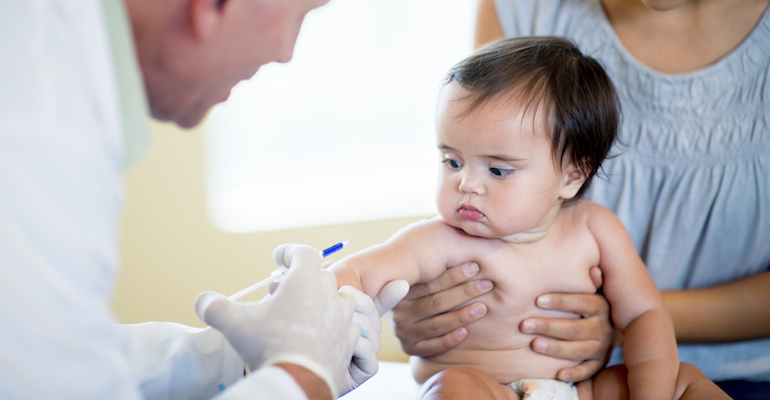 A baby getting a shot, adopting a healthy child