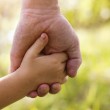 A grandfather and granddaughter, holding hands