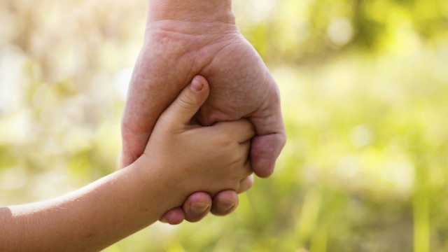 A grandfather and granddaughter, holding hands