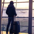 A woman at an airport, adopting while pregnant