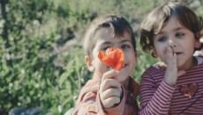 Twin boy and girl smelling flower, to represent selecting gender in adoption