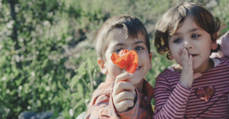 Twin boy and girl smelling flower, to represent selecting gender in adoption