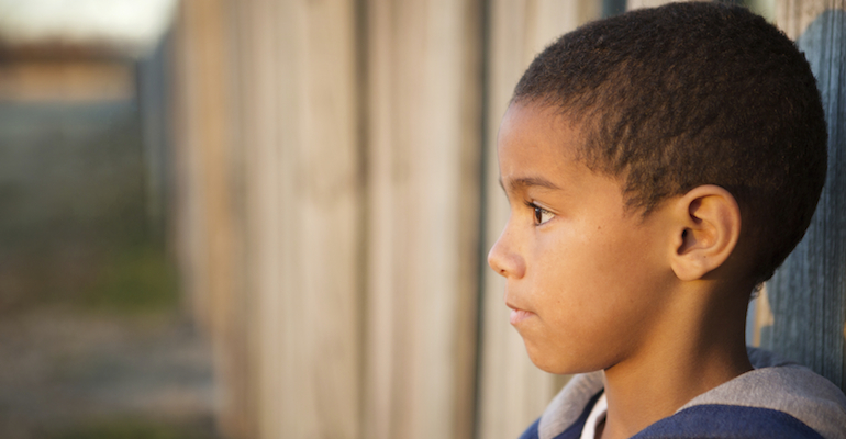 A serious child, contemplating the decline in foster adoptions