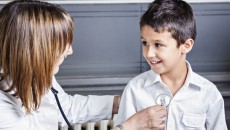 A pediatrician utilizing new health care guidelines for foster children on a small boy