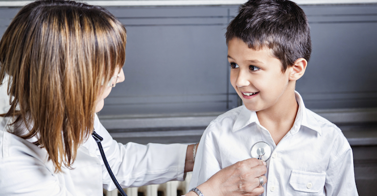 A pediatrician utilizing new health care guidelines for foster children on a small boy