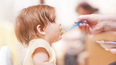 A parent feeding their child with tips learned from Love Me, Feed Me