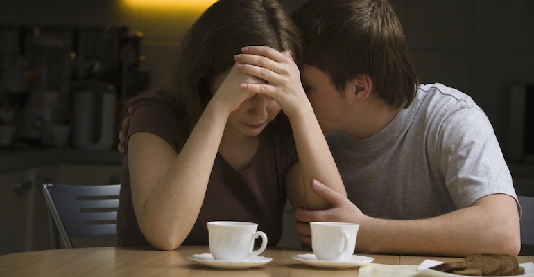 Man consoling upset woman, who is wondering "What if my adoption fails?"