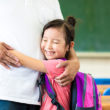 Girl hugging father in her inclusive, adoption-friendly classroom