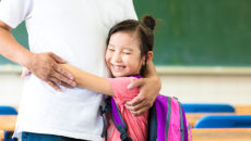 Girl hugging father in her inclusive, adoption-friendly classroom