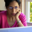 A prospective adoptive mom reading adoption websites on her laptop computer