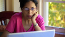 A prospective adoptive mom reading adoption websites on her laptop computer