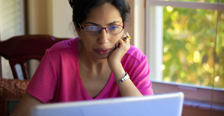 A prospective adoptive mom reading adoption websites on her laptop computer
