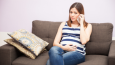 An expectant mother who is considering adoption talks on the phone