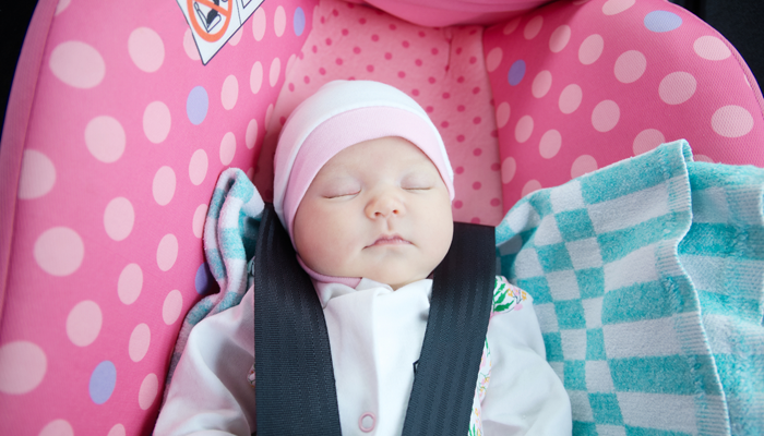 A baby who was adopted domestically travels home in a car seat