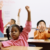 diverse adopted children raising their hands in a classroom, feeling safe at school