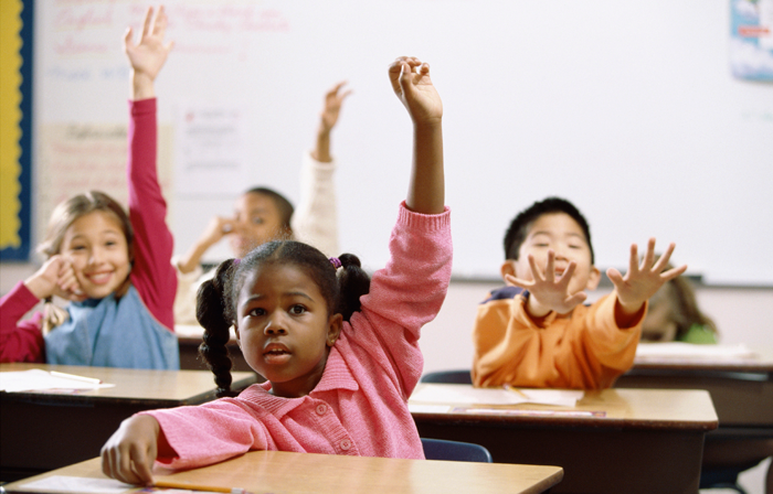 diverse adopted children raising their hands in a classroom, feeling safe at school