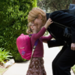 working adoptive mother and child hug before they head to school and work