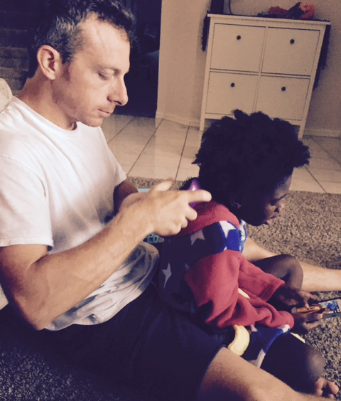 A transracial adoptive father detangles his black daughter's hair