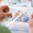 a woman looks through an album, holding a photo of her biological brother from one of his visits