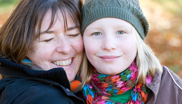 An adoptive mother hugs her preteen daughter after a good talk about adoption