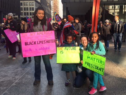 author Karla Thomas and her family holding "Black Lives Matter" signs at a march